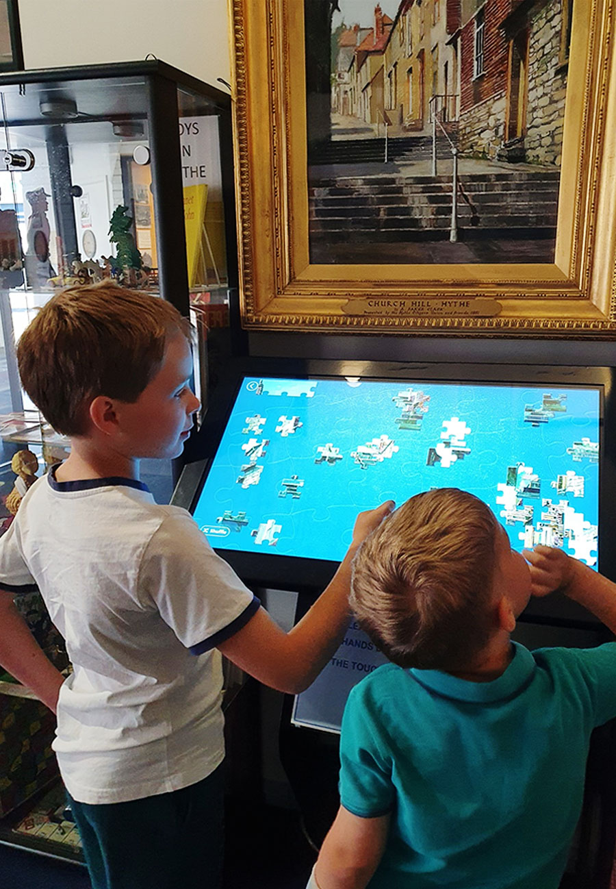 32 Inch Kiosk with Lightbox 3 Puzzle being used at Hythe Local History Museum