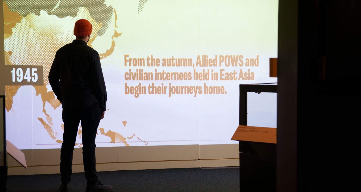 Man in front of projected screen at National Archives' Great Escape exhibition